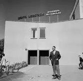 En man. Direktör Bertil Liedström
. Fabriksbyggnad i bakgrunden.
Bertil Liedström Byggnads AB byggde bl. a. polishuset på Stortorget.