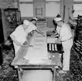 Bageriinteriör, bagerimaskin, fem män.
Blomé & Co, Topp Industri.