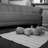 Rumsinteriör, en liten pojke på mattan.
Patrik