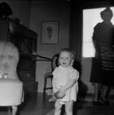 Rumsinteriör, en kvinna och en liten flicka.
Rittbergs dotter på 1-årsdagen.