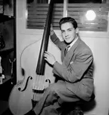 En man med musikinstrument (bas).
Skandia