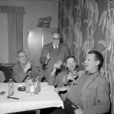 Rumsinteriör, grupp fyra män vid bordet.
Sjömark & Co, Ring-Centralen.