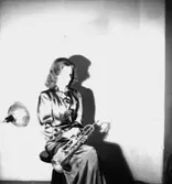 En kvinna med musikinstrument (trumpet).
Thory Bernhard