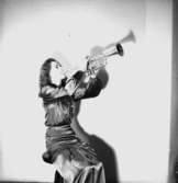 En kvinna med musikinstrument (trumpet).
Thory Bernhard