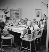 Rumsinteriör, barnkalas, grupp vid bordet.
Doris Landekvist