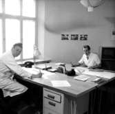 Ahréns Arkitektkontor, interiör, två män vid skrivbordet.