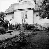 Thyra Anderssons pensionat, exteriör.
En kvinna framför byggnaden.