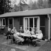 Envånings bostadshus, sju personer vid bordet framför huset. Kexens Personalklubb hos Eivor Johansson.
Örebro Kexfabrik.