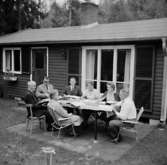 Envånings bostadshus, sju personer vid bordet framför huset. Kexens Personalklubb hos Eivor Johansson.
Örebro Kexfabrik.