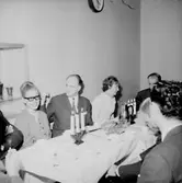 Rumsinteriör, grupp vid bordet, Luciafirande.
Örebro Kexfabrik.