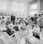 Rostaskolan, klassrumsinteriör, skolbarn med lärarinna. 
Sussis och Hasses examen.
Examen i andra klass,1961. Lärarinna Märta Ljung