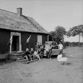 Familjegrupp på resan.
Envåningsbostadshus.