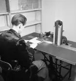 Konsum, kontorsinteriör, maskin för kortregistrering, en man.