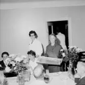 Rumsinteriör, grupp vid bordet, Kexens pensionärer. Personalklubben uppvaktar.
Örebro Kexfabrik.