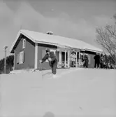 Skidåkning, fem personer.
Envånings byggnad.