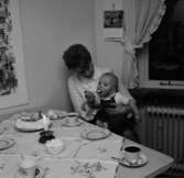 Rumsinteriör, en kvinna och en pojke vid bordet.
Patrik på 1-årsdagen.