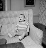 Rumsinteriör, en liten pojke i soffan.Beijer