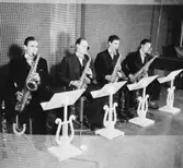 Whispering Band, fyra män med musikinstrument.