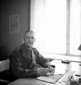 Fo-staben, kontorsinteriör, en man vid skrivbordet.
Major Hård