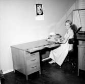 Kontorsinteriör, en kvinna vid skrivmaskinen.
Wigrell & Co.