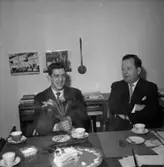 Interiör, två män, uppvaktning.
Wigrell & Co.