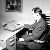 Kontorsinteriör, en man vid skrivbordet.
Wigrell & Co, utställning på Idrottshuset.