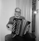 En man med musikinstrument (dragspel).
Börje Wizell