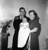 Rumsinteriör, familjegrupp tre personer, barndop.
Grims