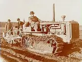 Tre män, en traktor av märket Caterpillar diesel.
(JUF) Örebrobygdens JUF-avd.