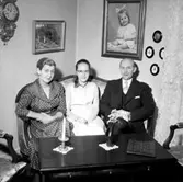 Rumsinteriör, familjegrupp tre personer.
Rohland Ohlssons 50-årsdag.