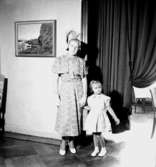 Rumsinteriör, en kvinna och en liten flicka.Bertil Sehlin (beställare).