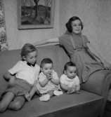 Rumsinteriör, fyra barn i soffan.Fru Blomberg