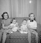 Rumsinteriör, fyra barn i soffan.Fru Blomberg