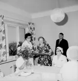 Rumsinteriör, grupp vid bordet, Kexens pensionärer. Personalklubben uppvaktar.
Örebro Kexfabrik.