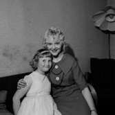 Rumsinteriör, en kvinna och en flicka.Fru Svea Edwardssons 50 årsdag.