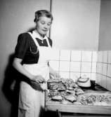 Rumsinteriör, bakning, en kvinna.
Fru Hellkvist
Konsum