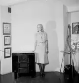 Rumsinteriör, en kvinna.
Konsum Special.