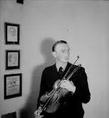 Rumsinteriör, en man med musikinstrument (fiol).
Storå