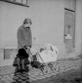 En kvinna och ett barn i barnvagnen.
Plutt och Patrik