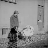 En kvinna och ett barn i barnvagnen.
Plutt och Patrik