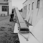 Vretstorpsverken, fabriksbyggnader, transportband, en man.