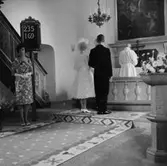 Interiör av Gällersta kyrka, bröllop, brudpar, bröllopsgäster och en präst.
Ramströms bröllop.