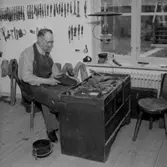 Skomakare i Wadköping, interiör, skotillverkning, en man.
Beställare: Sedellls.