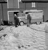 Stubbetorps Kontrollhönseri, lastbil och två personer.
Byggnad.