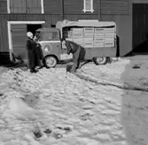 Stubbetorps Kontrollhönseri, lastbil och två personer.
Byggnad.