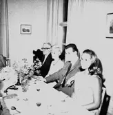 Interiör, grupp vid bordet.
Lindmans 50-årsdag.
