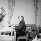 Rumsinteriör, vävning, en kvinna.
Eiris Nyström