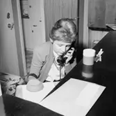 Kontorsinteriör, en kvinna vid telefonen.
Sedell Reklam.