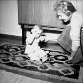 Rumsinteriör, en kvinna och ett litet barn.Sjunnesson