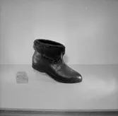 En sko - känga.
Oscaria Skofabrik.